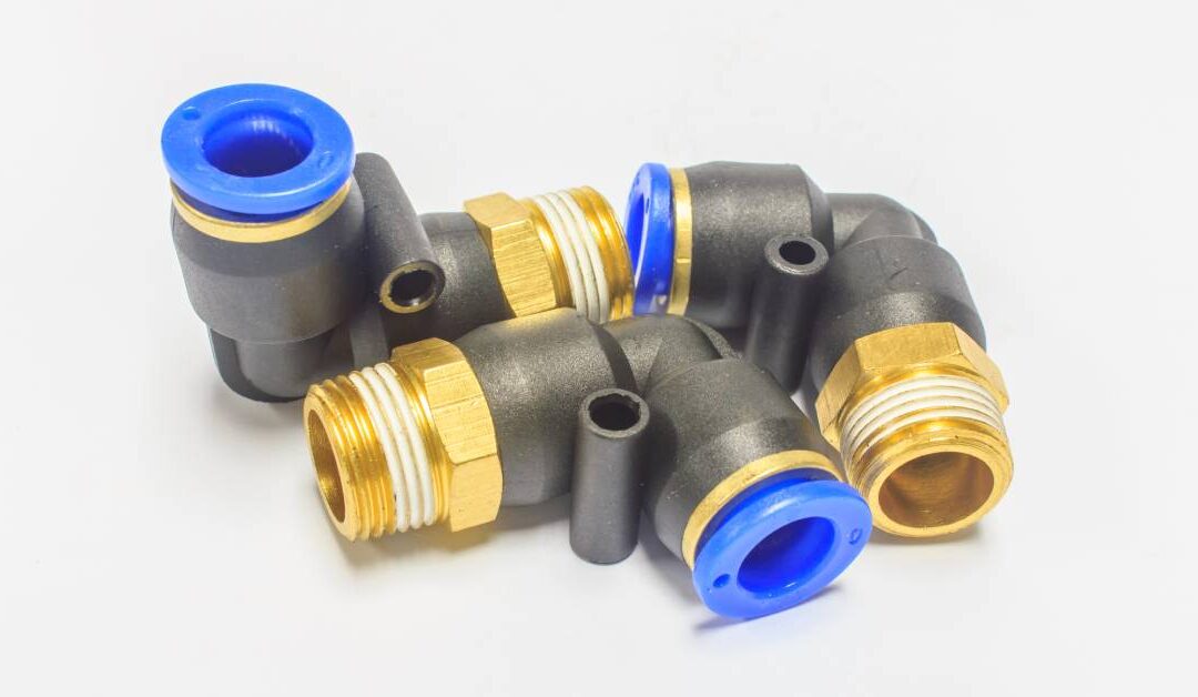 Three pipe connectors with black bases and gold threads. There are blue plastic plugs attached to one end of each connector.