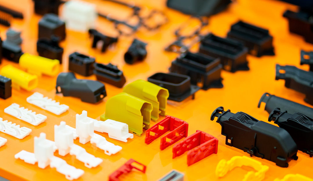 A wide range of plastic parts on an orange tray. There are some parts that are lying flat while others are standing.