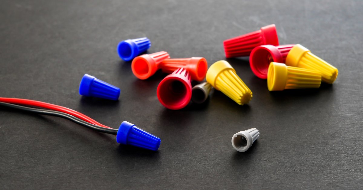 Colorful connection caps that vary in size. There are red and black wires attached to a blue connection cover.